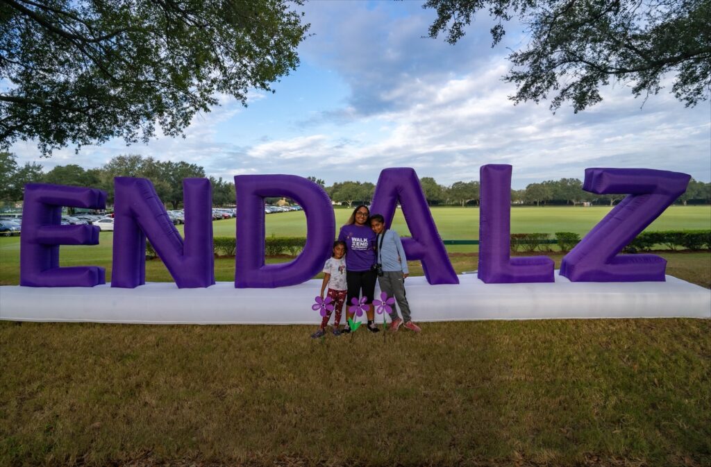 Rebecca Persaud and her children at the Walk to End Alzheimer’s in The Villages, Florida. Their purple flowers represent two family members with Alzheimer’s, Persaud’s grandmother and aunt, that they walked in memory of.